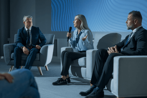 a corporate convention with three speakers on stage